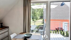 Une pièce moderne comprenant une table à manger, des chaises, un saladier et un luminaire suspendu.