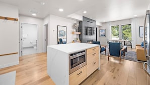 Une cuisine moderne dotée d’un îlot central, de meubles en bois et d’appareils électroménagers intégrés.