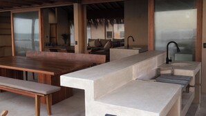 Une cuisine moderne avec un plan de travail en pierre, une table à manger en bois et des bancs.