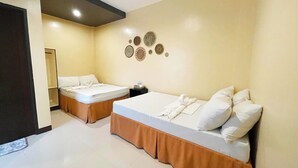 A hotel room with two beds, a small table, and wall decor. - AltaVista Beach Resort Samal powered by Cocotel (Samal)
