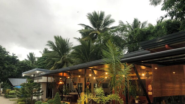 A restaurant with outdoor seating, surrounded by lush greenery and palm trees. - AltaVista Beach Resort Samal powered by Cocotel (Samal)