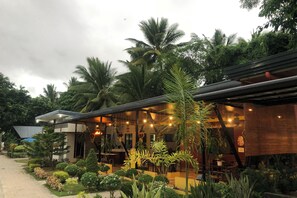 A restaurant with outdoor seating, surrounded by lush greenery and palm trees. - AltaVista Beach Resort Samal powered by Cocotel (Samal)