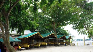 A beachside area with wooden structures, benches, and a sandy ground. - AltaVista Beach Resort Samal powered by Cocotel (Samal)