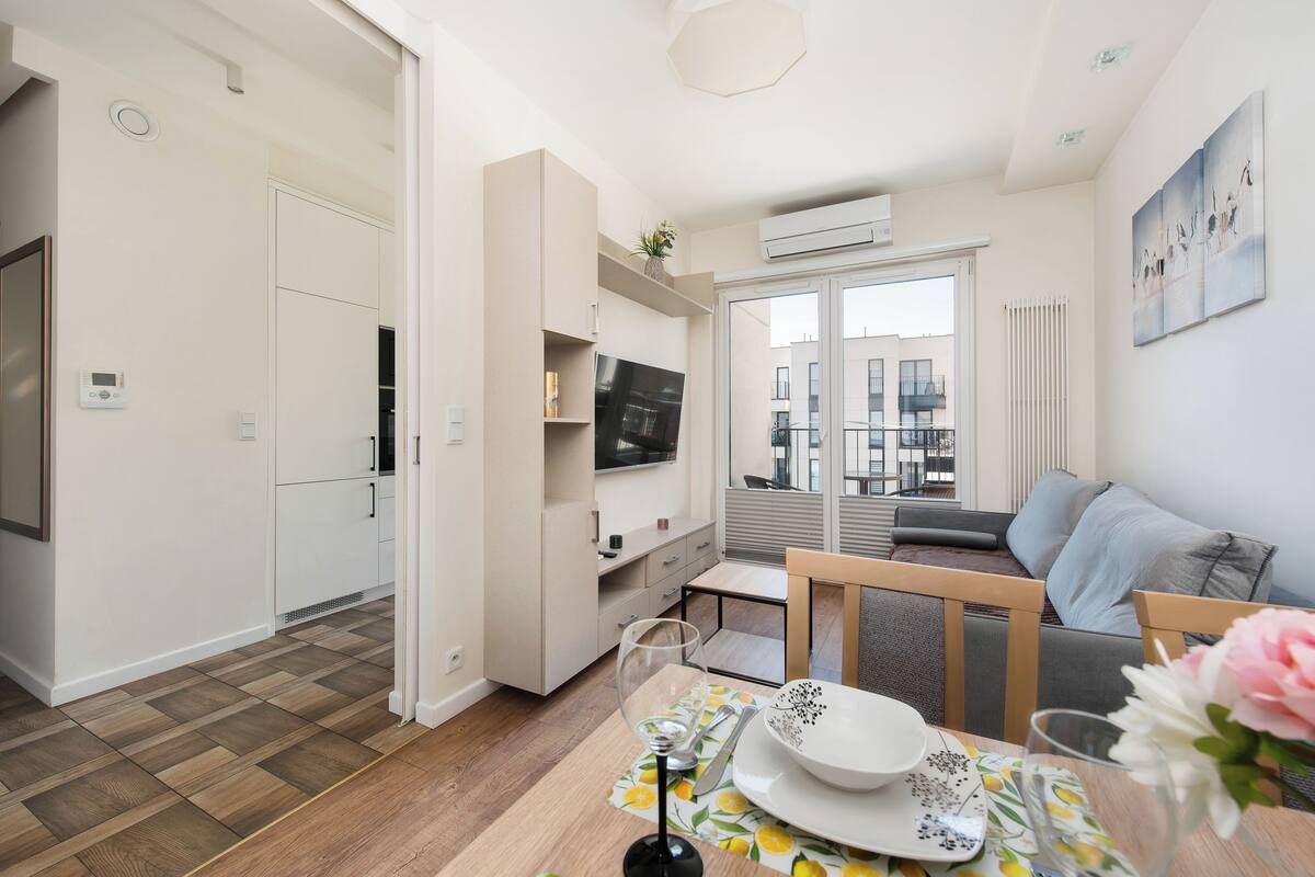 A modern apartment with a dining area, kitchen, and living room.
