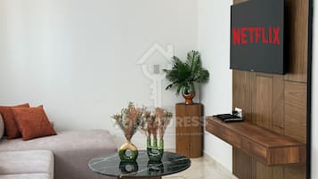 Apartamento Signature | Zona de estar | Smart TV de 50 pulgadas con canales por satélite