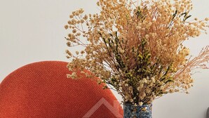 A dining table with a vase of dried flowers, a green mug, and a brown bowl. - Youradress (Casablanca)