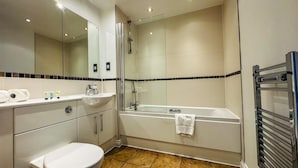 A modern bathroom with a toilet, sink, and bathtub. - Oval House Retreat in Camden Town (London)