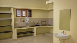 A bathroom with a sink, mirror, and shelves.
