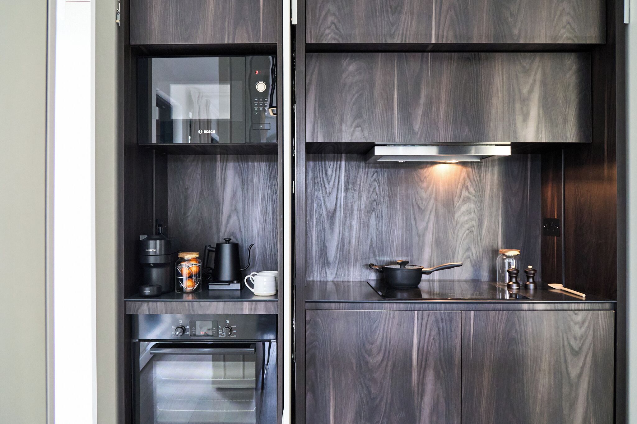 Cocina compacta equipada con microondas, cafetera y horno.
