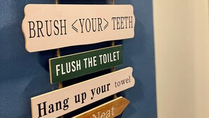 Een bord aan de muur met regels voor het toilet.