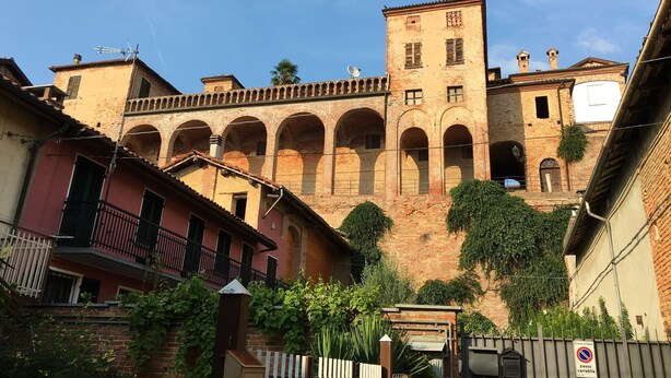 A historic building with arched walkways and a central tower.