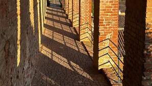 A corridor with brick arches and a brick floor.