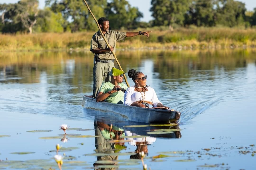 A boat on a calm water body with lily pads, surrounded by greenery.