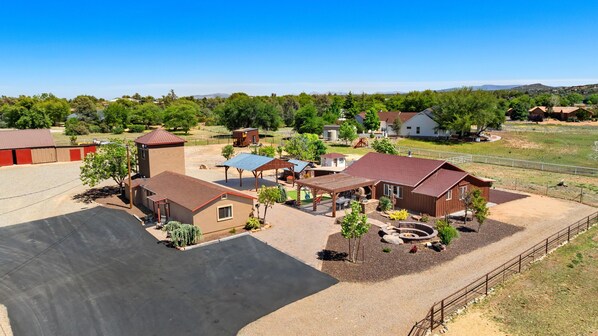 A residential area with multiple houses, a fenced yard, and a large open space.