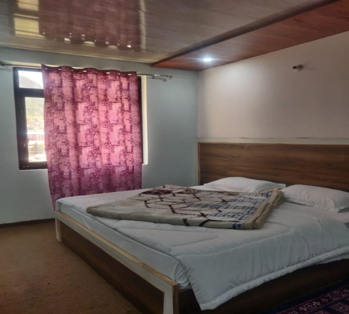 Una camera da letto con un letto, una finestra con tende e una testiera.