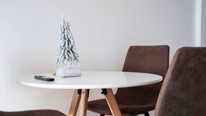 A round white table with a small white Christmas tree and a remote control on it. - MaRKoS Flat in F3 New Gudauri RedCo (New Gudauri)