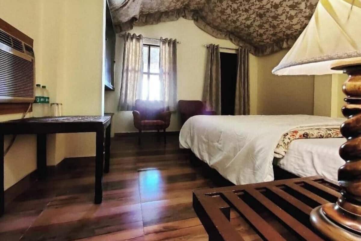 Ein Zimmer mit einem Bett, einem Schreibtisch, einem Stuhl und einer Lampe.