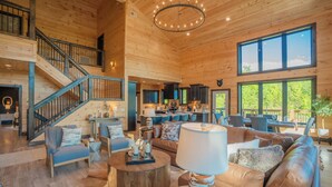 A spacious wooden interior with a staircase, a dining area, and a kitchen.