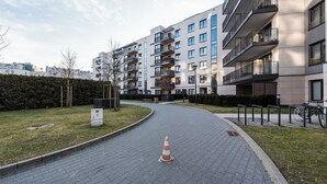 Um prédio de apartamentos moderno com várias varandas e um caminho pavimentado.