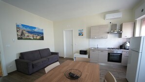 A modern apartment with a dining area, kitchen, and living space.