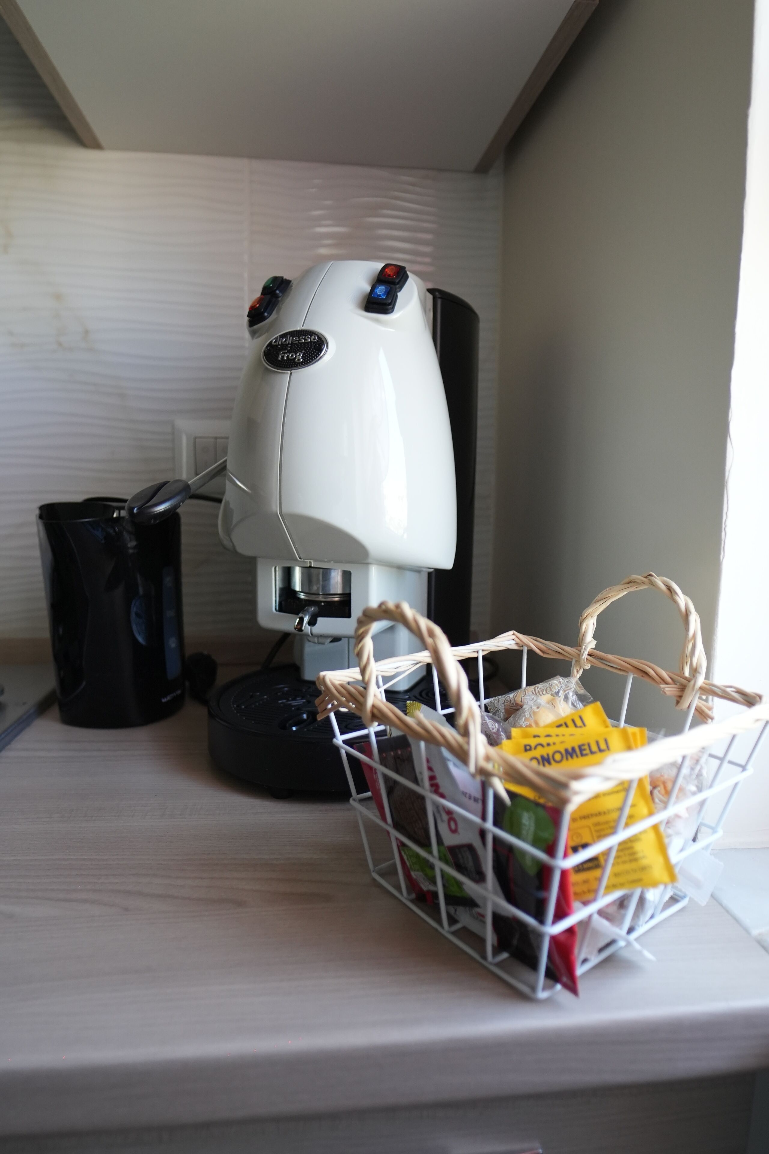 A coffee machine with a basket of coffee pods on a countertop.