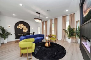 Relax in this stylish living room with a blue sofa, armchair, and flat-screen TV.