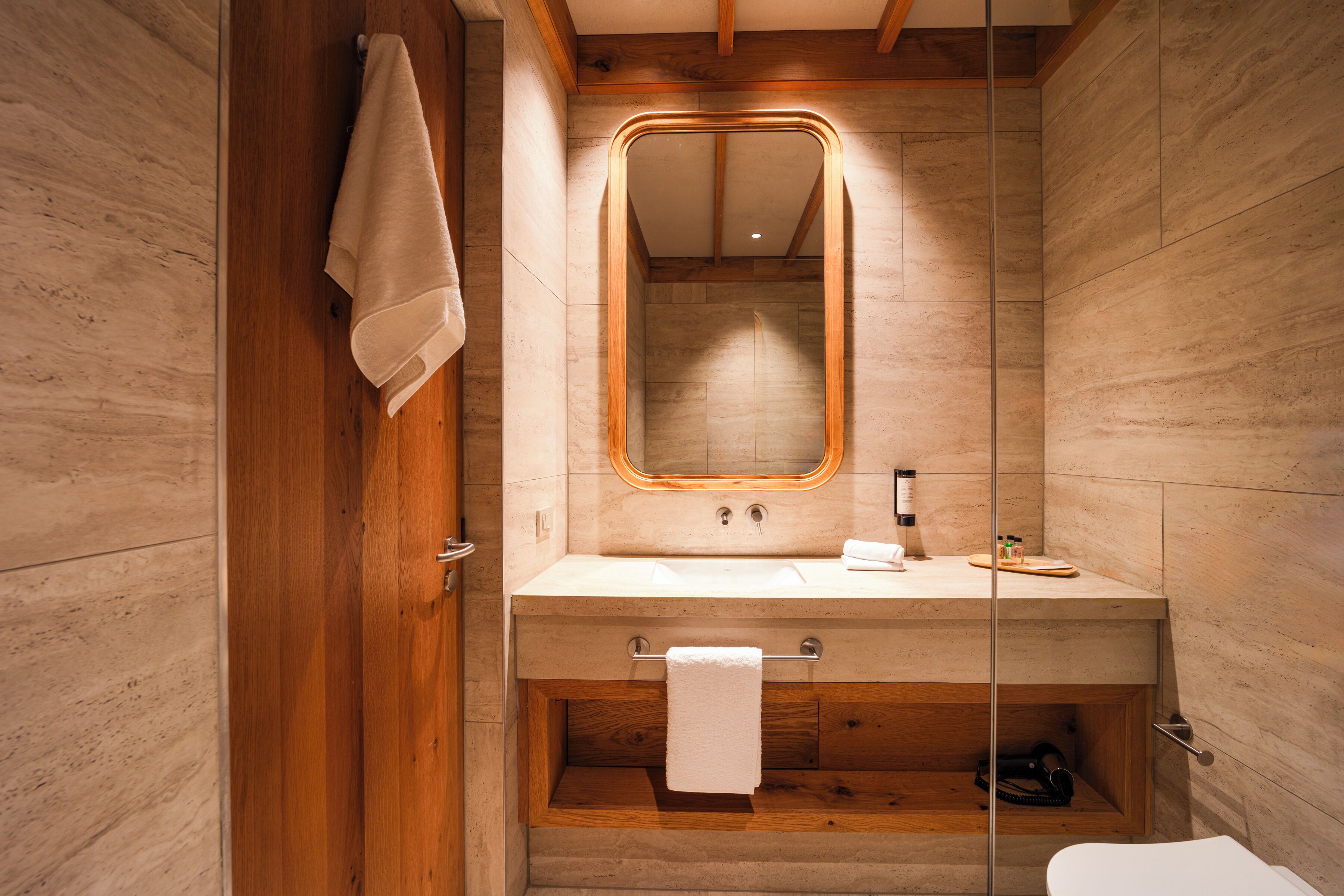 Une salle de bain moderne avec un meuble-lavabo en bois, un miroir et un porte-serviettes.