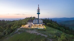 A large house with a tall tower, surrounded by greenery and hills. - Hochblauen Hotel (Schliengen)