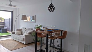 Un comedor moderno con una mesa de madera, dos sillas y una lámpara colgante.