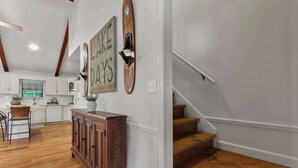 A kitchen with white cabinets, a wooden cabinet, and a sign that says 'LAKE DAYS'.
