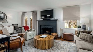 Una sala de estar moderna con chimenea, televisor y un rincón de descanso acogedor.