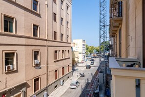 A multi-story building with a street view, including parked cars and a construction crane.