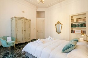 Ein Hotelzimmer mit Bett, Schrank, Stuhl, Spiegel und Bücherregal.