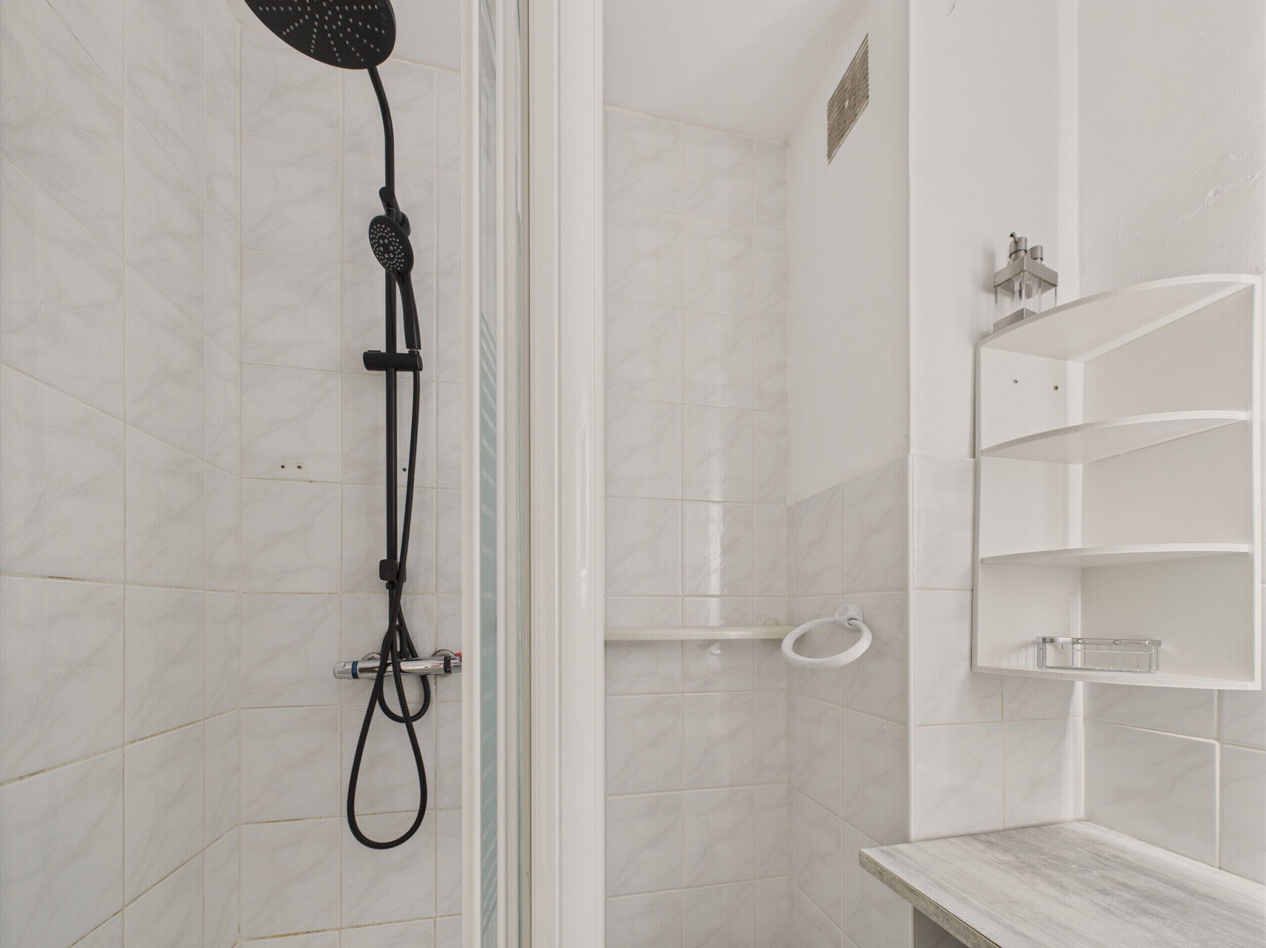 A modern bathroom with a shower, a toilet, and a sink.