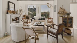 Un salon spacieux doté d’une cheminée, de sièges confortables et offrant une vue sur l’extérieur.
