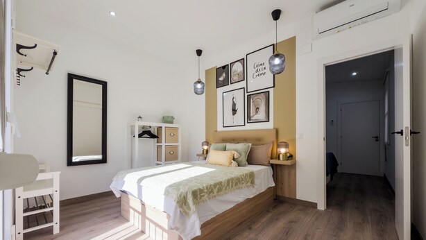 Un dormitorio con cama, mesitas de noche, armario y espejo.