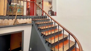 A staircase with a wooden handrail, a sign reading "ANTIQUE," and a red door in the background. - Quality LOFT for 4 people (Lamalou-les-Bains)