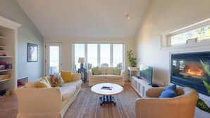 A living room with a fireplace, a sofa set, a coffee table, and a TV.