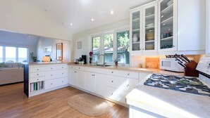 A modern kitchen with white cabinetry, a built-in microwave, and a gas stove.