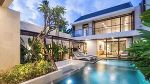 A modern house with a swimming pool, outdoor seating, and lush greenery. - Chic 3BR Hideaway Canggu • AC • 5min to Beach (Kecamatan Kuta Selatan)