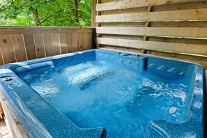 A hot tub with a wooden deck and a wooden wall in the background. - Peaceful 2BR w/Hot Tub*Game Room*Jacuzzi*Privacy! (Sevierville)