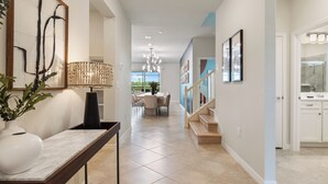 A modern interior with a dining area, staircase, and kitchen.