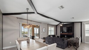 A spacious living area with a dining table, sofas, and a fireplace.