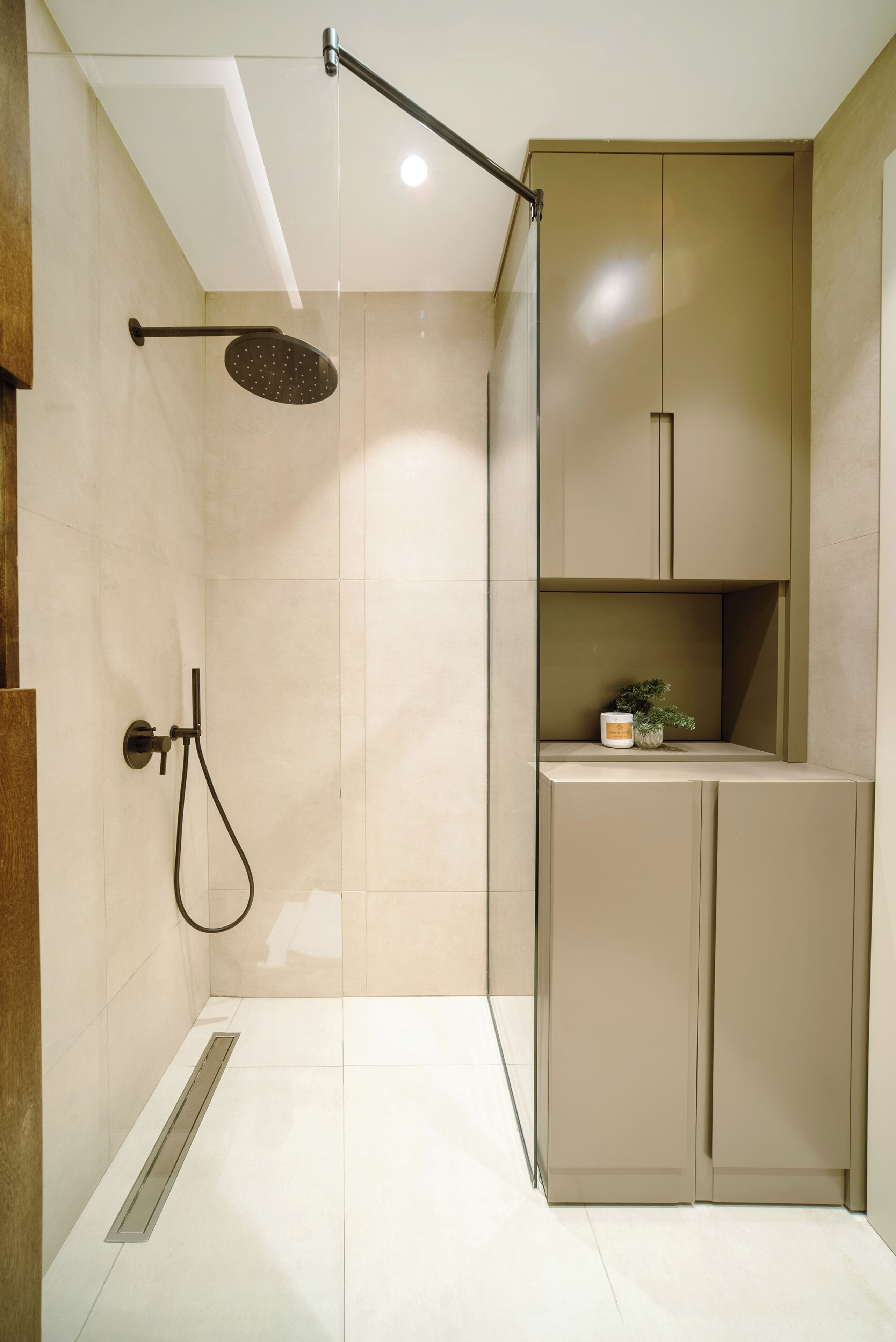 A modern bathroom with a shower, toilet, and storage cabinets.