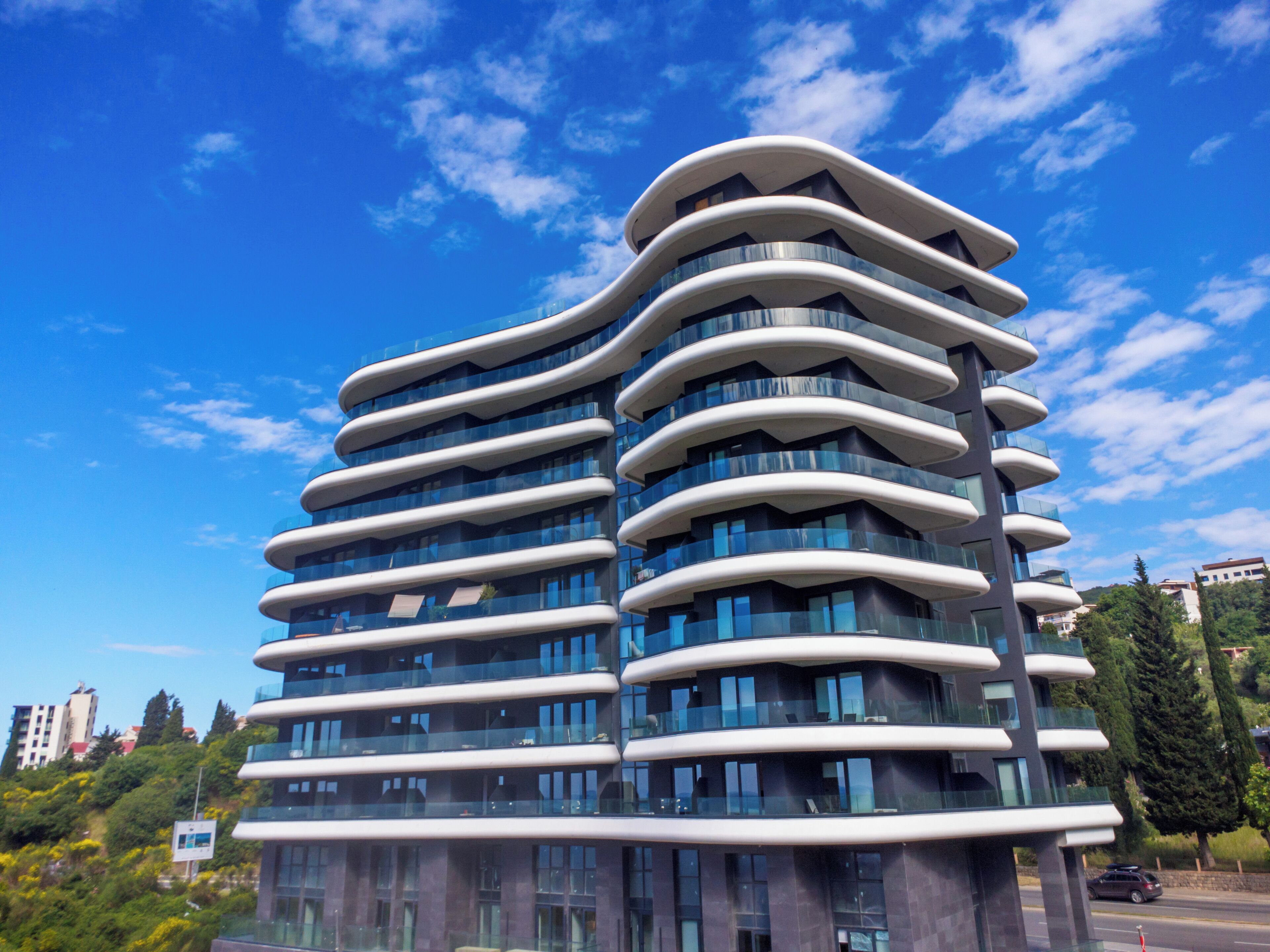 Un edificio moderno de varios pisos con fachada curva y ventanas amplias.