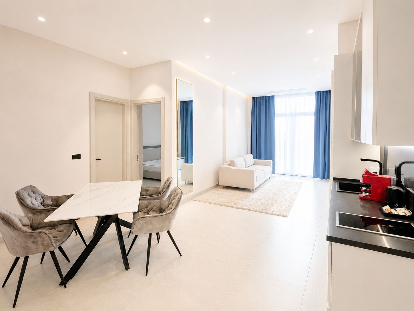Una habitación de hotel moderna con comedor, kitchenette y sala de estar.