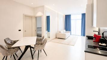 Una habitación de hotel moderna con comedor, kitchenette y sala de estar.