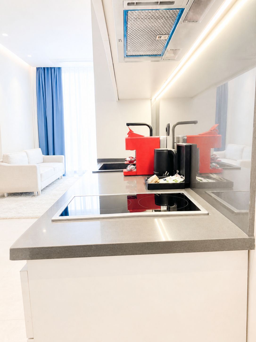 A modern kitchen with a built-in stove, a coffee machine, and a sink.