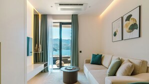 Un salon moderne avec un canapé, une table basse et une vue sur l’extérieur.
