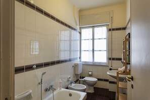 A bathroom with a bathtub, toilet, and bidet.